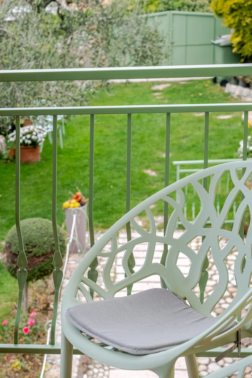 Dettaglio del giardino: sedia verde decorata vista dalla terrazza
