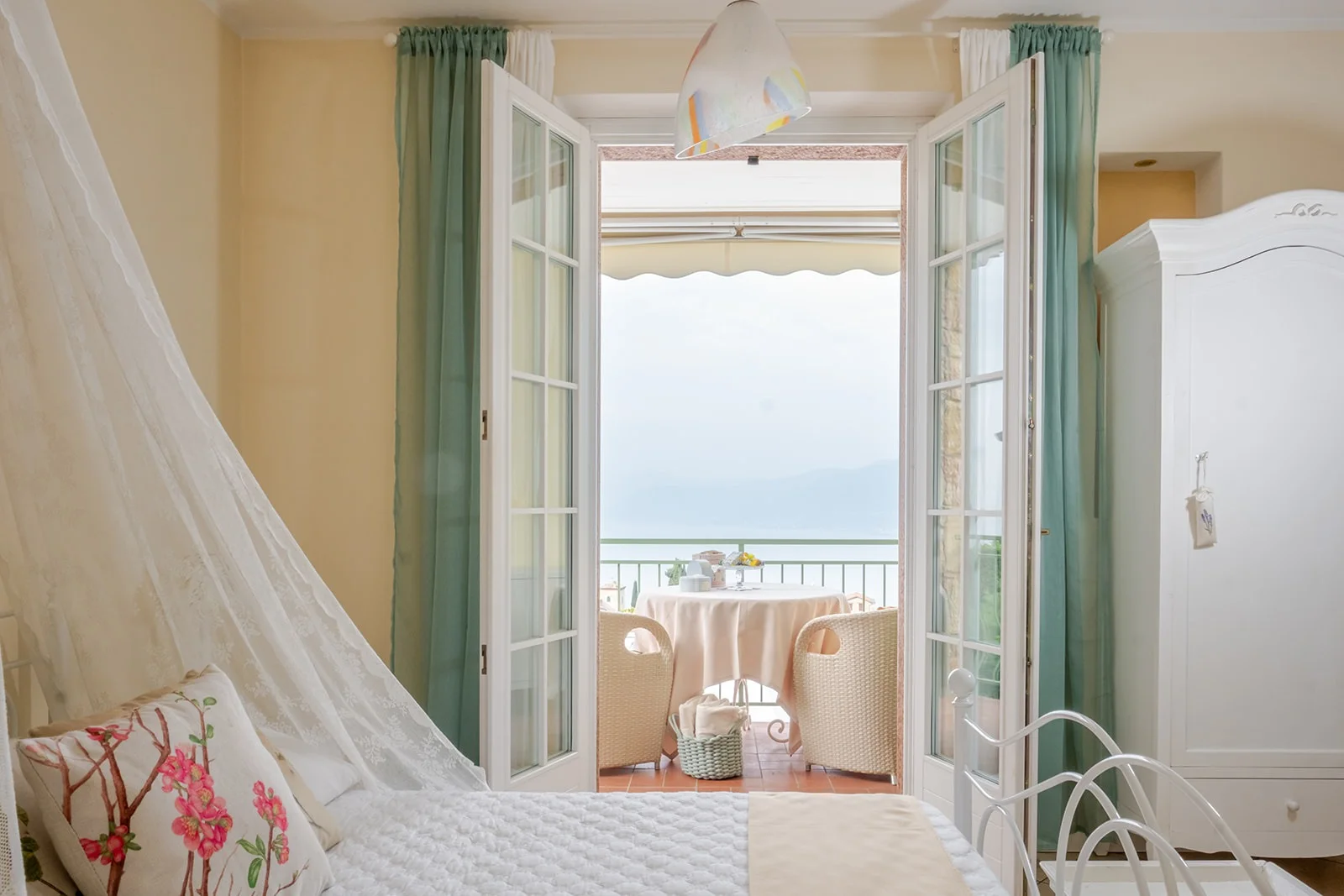 Gemme Suite: camera con porta-finestra aperta sulla terrazza con vista Lago di Garda