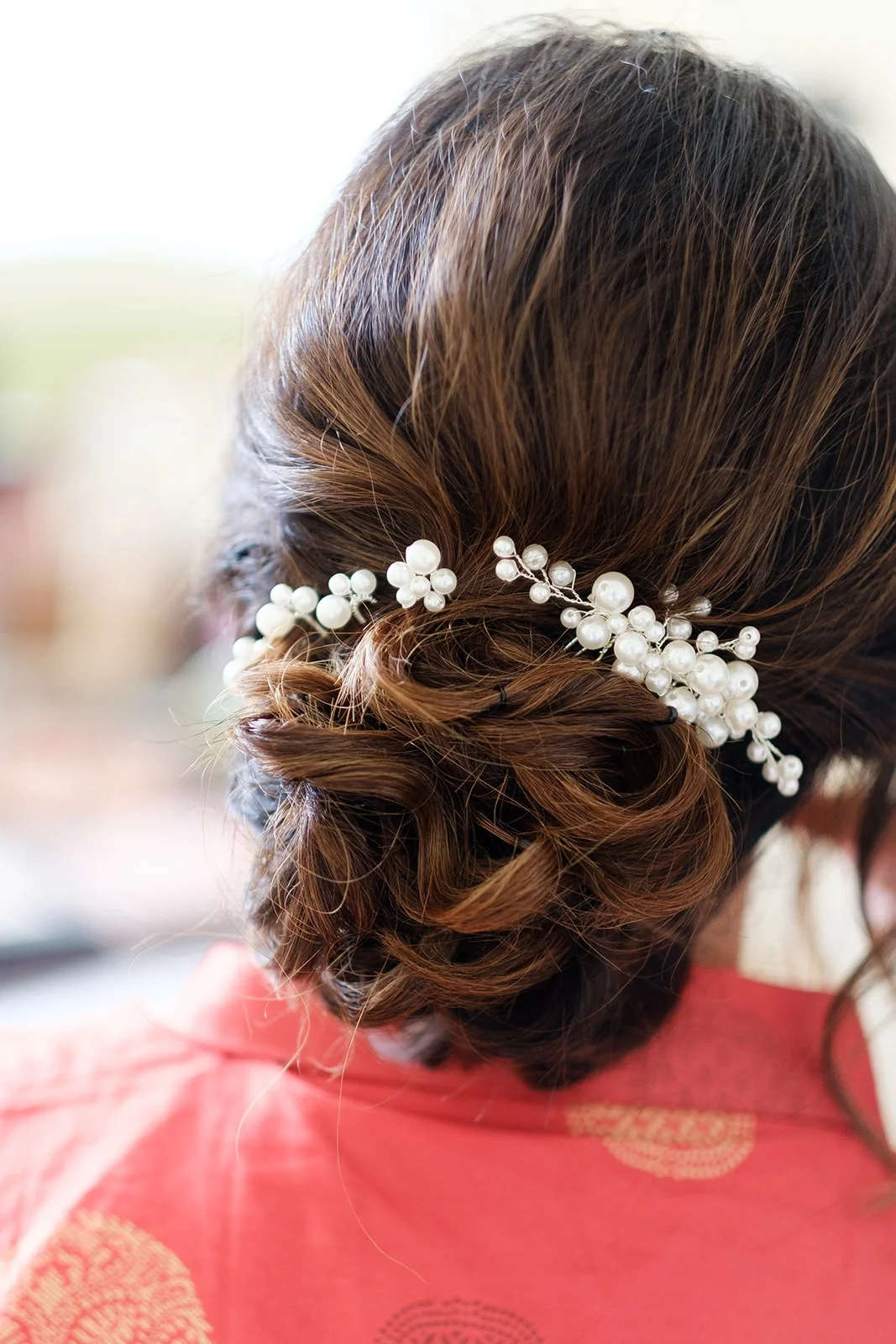 Acconciatura della sposa con fermaglio di perle e velo di tulle