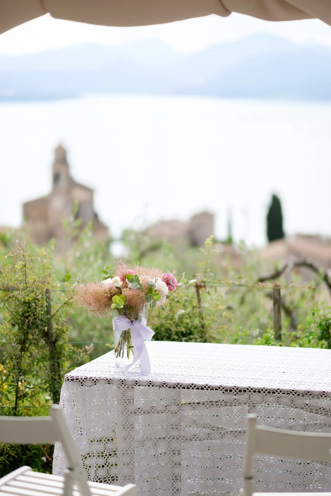 Bouquet sposi su tavolo con vista sul Lago di Garda